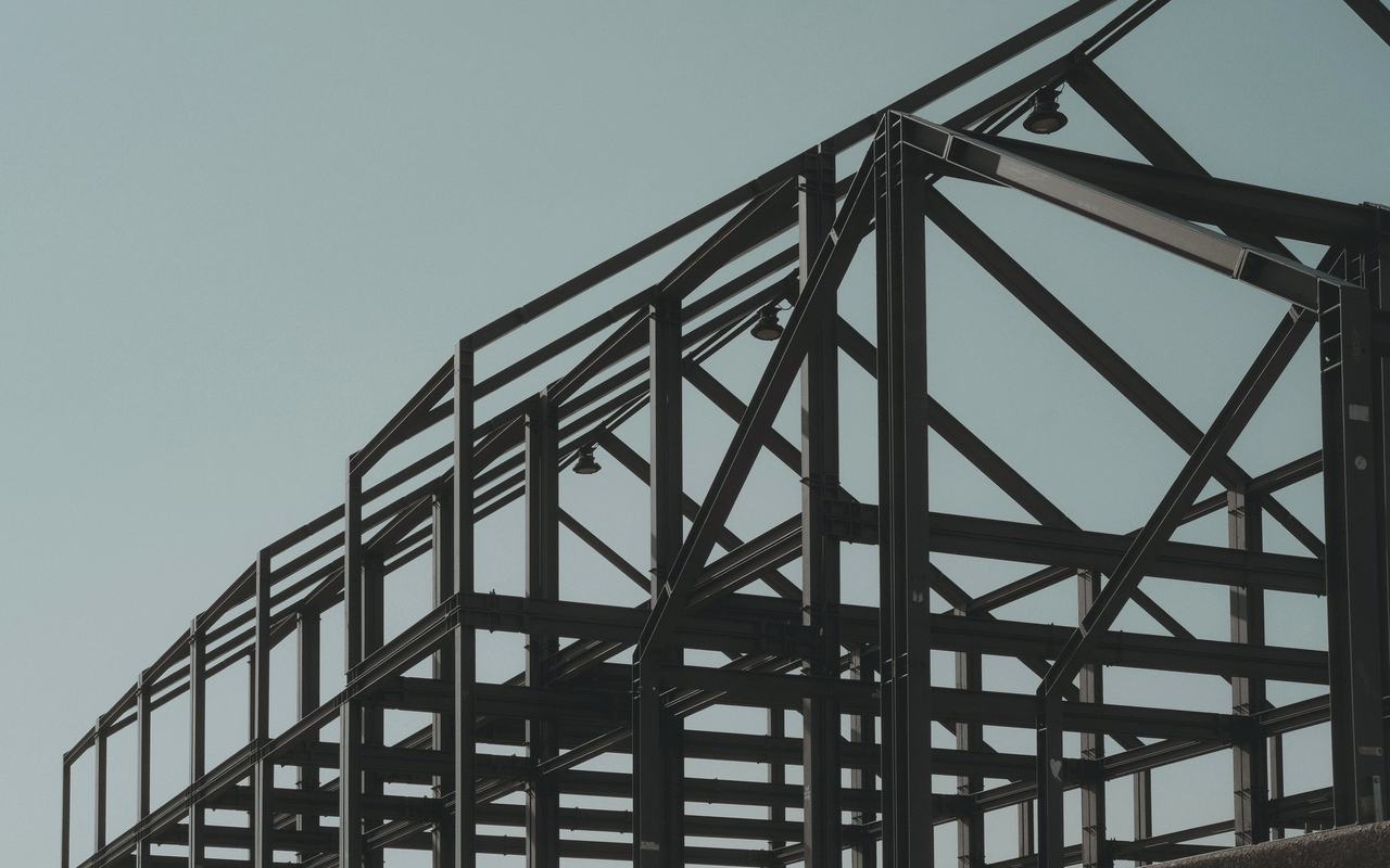 Modern steel framework structure under clear sky, showcasing architectural design.