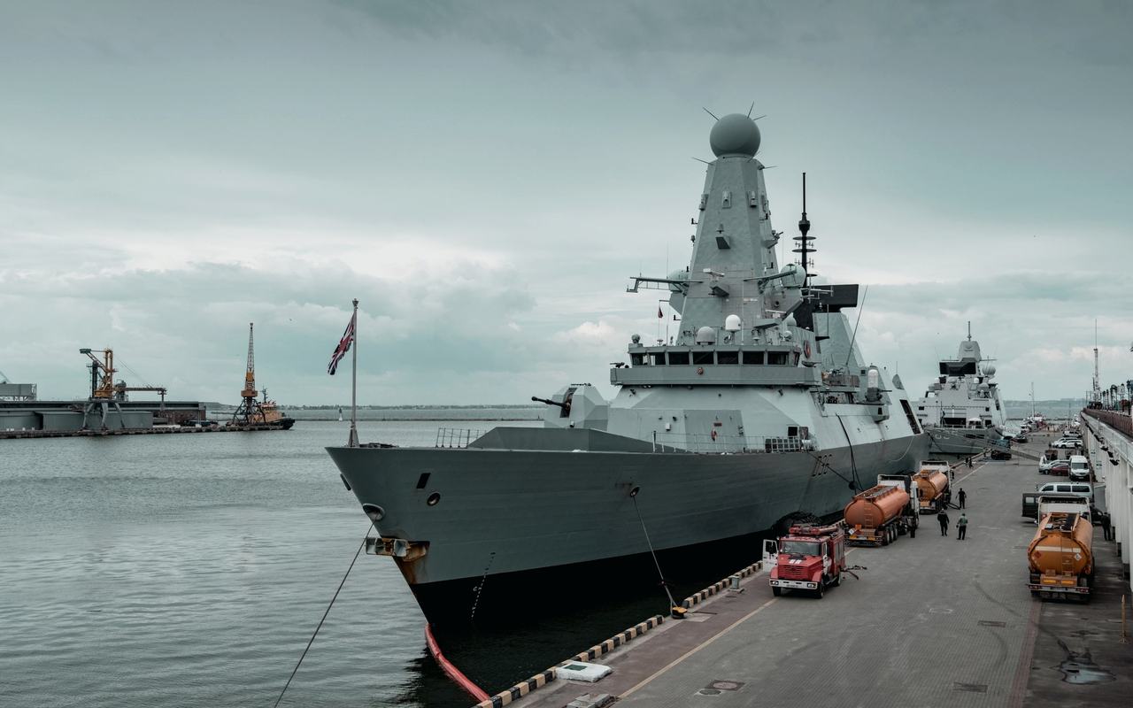 A navy destroyer docked at Odesa harbor with cloudy sky, highlighting maritime defense.